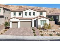 Stunning two-story home featuring a three-car garage, desert landscaping, and a charming front porch at 3998 Montone Ave, Las Vegas, NV 89141
