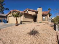 Single story home with desert landscaping, garage, and red tile roof at 7324 Saybrook Point Dr, Las Vegas, NV 89128