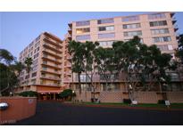 Multi-story building with balconies, mature landscaping, and covered entrance at 205 E Harmon Ave # 121, Las Vegas, NV 89169