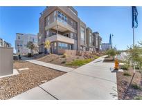 Modern townhomes featuring concrete sidewalks, tiered landscaping and a peek at neighborhood amenities at 2503 Cracked Stone St, Henderson, NV 89044