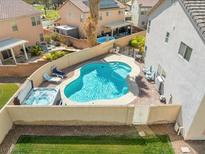 Beautiful backyard oasis with a sparkling pool, spa, and lush greenery at 5009 Rustic Charm Ct, Las Vegas, NV 89131