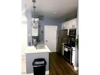 Well-lit kitchen featuring stainless steel appliances, white cabinets, and stylish countertops at 7131 S Durango Dr # 306, Las Vegas, NV 89113