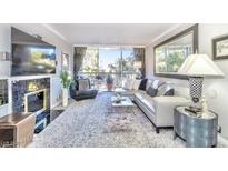 Bright living room with plush carpeting, large windows with view, and a decorative fireplace and entertainment center at 730 S Royal Crest Cir # 424, Las Vegas, NV 89169