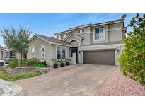 Stunning two-story stucco home boasts a tile roof, a brick driveway and a two-car garage at 10397 Walking View Ct, Las Vegas, NV 89135