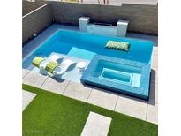 Inviting pool area features a spa, lounge chairs, and a built-in fire pit for relaxation and entertainment at 12451 Island Bells Ave, Las Vegas, NV 89138