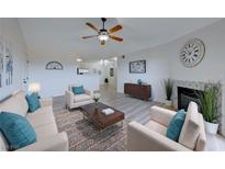 Open living room with fireplace, ceiling fan, neutral colors, and lots of natural light at 231 W Horizon Ridge Pkwy # 1027, Henderson, NV 89012