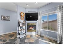 Inviting living room featuring a cozy fireplace, neutral color palette, and natural light from the large window at 262 Big Horn Dr, Boulder City, NV 89005