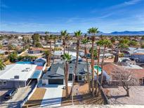 Charming single-story home with well-manicured lawn and several palm trees on a sunny day at 5209 Champions Ave, Las Vegas, NV 89142