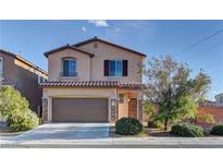Charming two-story home featuring a covered porch and attached garage, showcasing a well-maintained lawn and inviting curb appeal at 6307 Point Isabel Way, Las Vegas, NV 89122
