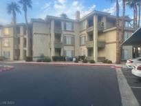 Condominium exterior featuring multiple units with palm trees on a sunny day at 7173 S Durango Dr # 308, Las Vegas, NV 89113