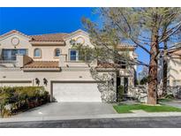 Charming two-story townhome featuring a two-car garage and well-maintained landscaping at 8740 Carlitas Joy Ct, Las Vegas, NV 89117