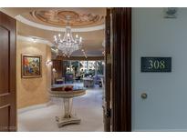 Elegant condo foyer features a crystal chandelier, round table, and an open view to the spacious living area at 1 Hughes Center Dr # 308, Las Vegas, NV 89169