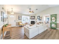 Open living room featuring a fireplace, ceiling fan, wood flooring, and neutral decor at 3192 Taylor St, Logandale, NV 89021