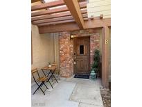 Charming brick-accented front entrance featuring a wooden pergola and outdoor seating area at 3449 Lorilou Ln # 2, Las Vegas, NV 89121
