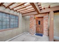 Charming entryway features a brick facade, wooden door, and a cozy, covered porch area at 3449 Lorilou Ln # 2, Las Vegas, NV 89121