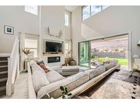 Bright living room with high ceilings, modern fireplace, and sliding glass doors to the backyard patio at 421 Malpaso St, Las Vegas, NV 89138