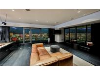 Modern living room features a leather sofa, sleek design, and panoramic city views through floor-to-ceiling windows at 4381 W Flamingo Rd # 5708, Las Vegas, NV 89103