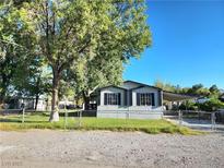 Charming home exterior with mature trees and a well-maintained lawn with a covered carport at 603 Virginia Way, Indian Springs, NV 89018