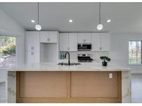 Modern kitchen featuring white cabinets, stainless steel appliances, and a large island with marble countertop at 9808 Eagle Rock Ct, Las Vegas, NV 89117