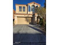 Two-story home featuring tan paint, attached two-car garage and arched entry at 9922 Stiges St, Las Vegas, NV 89178