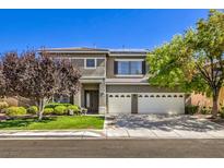 Charming two-story home featuring a balcony, manicured lawn, and a three-car garage at 10662 Bonchester Hill St, Las Vegas, NV 89141