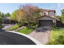 Charming two-story home featuring a three-car garage, lush landscaping and brick-paved driveway at 2285 Villefort Ct, Las Vegas, NV 89117