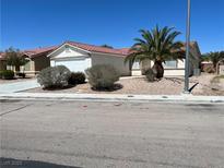 Charming single-story home featuring a red tile roof, low maintenance landscape, and an attached two-car garage at 3118 Honeysuckle Ave, North Las Vegas, NV 89031