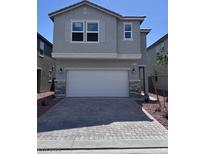 Two-story home features a gray exterior, a two-car garage, and a brick driveway at 6616 Bowery St, Las Vegas, NV 89148