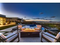 Inviting backyard featuring a pool, fire pit, and comfortable seating with city views at 678 Blackrock Rim Dr, Henderson, NV 89012