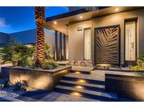 Contemporary home featuring a grand entrance with a tall palm tree and modern architectural details at 678 Blackrock Rim Dr, Henderson, NV 89012