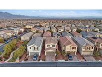 Expansive view of a neighborhood featuring uniform houses, neatly landscaped yards, and the mountain range backdrop at 7970 Calito St, Las Vegas, NV 89166