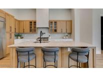 Modern kitchen showcasing wood cabinetry, stainless steel appliances, and a large center island with barstool seating at 8649 Robinson Ridge Dr, Las Vegas, NV 89117