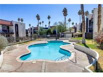 Resort-style pool and sundeck with lush landscaping, palm trees, and nearby condo buildings at 1405 Vegas Valley Dr # 286, Las Vegas, NV 89169