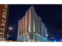 Night view of a luxury high-rise condo building with an illuminated parking garage in Las Vegas at 150 Las Vegas Blvd # 1608, Las Vegas, NV 89101