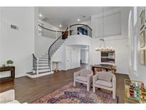 Bright living room featuring a grand staircase, hardwood floors, and elegant decor at 1754 Quiver Point Ave, Henderson, NV 89012