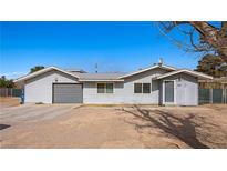 Single-story home featuring light gray siding, grey metal roof, a garage and minimal landscaping at 432 Bonelli Ave, Overton, NV 89040