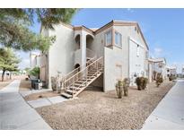 Beige stucco condo building featuring multiple units and exterior staircases on a sunny day at 4655 Gold Dust Ave # 139, Las Vegas, NV 89120