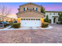 Inviting two-car garage with manicured shrubs, and a beautiful brick driveway at 9151 Mount Wilson St, Las Vegas, NV 89113