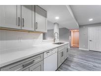 Modern kitchen featuring stainless steel faucet, quartz countertops, grey cabinets and wood-look laminate flooring at 220 Mission Catalina Ln # 202, Las Vegas, NV 89107