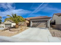 Charming single-story home featuring a well-manicured lawn and a two-car garage with decorative accents at 2210 Shadow Canyon Dr, Henderson, NV 89044