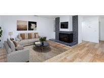 Bright living room featuring a fireplace, hardwood floors, and neutral-toned furniture at 2405 Pickwick Dr, Henderson, NV 89014