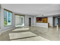 Bright living room with travertine floors, a modern kitchen, and large windows overlooking a city view at 322 Karen Ave # 201, Las Vegas, NV 89109