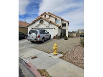 Two-story home featuring neutral stucco and tile roof in a desert landscape at 6624 Socorro Dr, Las Vegas, NV 89108