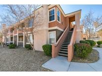Inviting condo featuring manicured landscaping, two stories, and exterior stairs leading to the upper level at 7700 Constanso Ave # 204, Las Vegas, NV 89128