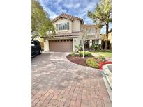 Charming two-story home features a brick driveway, a two-car garage and well-maintained landscaping at 11027 Dornoch Castle St, Las Vegas, NV 89141