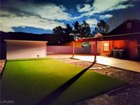 The backyard has an area of green artificial turf and a carport with a storage shed at 18 Allegro St, Blue Diamond, NV 89004