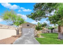 A one-car garage with a concrete driveway sits in front of a well-maintained lawn and mature trees at 2136 Velvet Hill Ave, Las Vegas, NV 89106