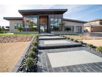 Modern home featuring a sleek exterior, well-manicured landscaping, and an inviting walkway to the front door at 3030 S Formula Ct, Pahrump, NV 89048