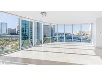 Bright living room featuring floor-to-ceiling windows with city views and tile flooring at 322 Karen Ave # 808, Las Vegas, NV 89109