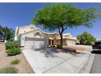 Charming two-story home featuring a well-manicured lawn, mature tree, and an attached two-car garage at 326 Lander Dr, Henderson, NV 89074